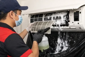 Professional aircon chemical wash showing technician applying foam to evaporator coils in Selangor